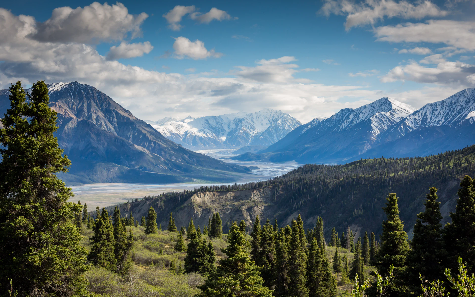 Dramatic alpine peaks rising above a green mountain valley